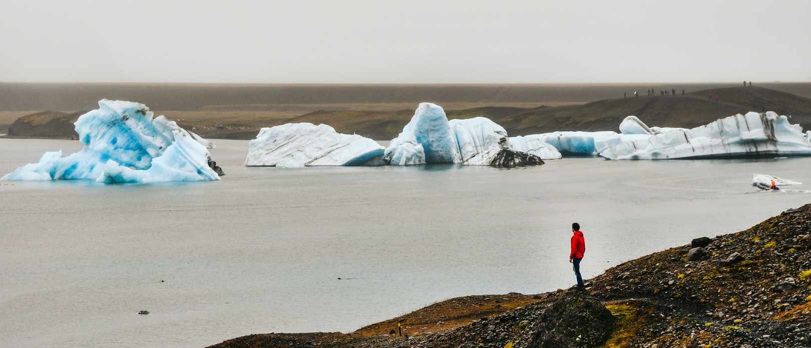 Person standing by lake with large bits of ice. Location is Iceland