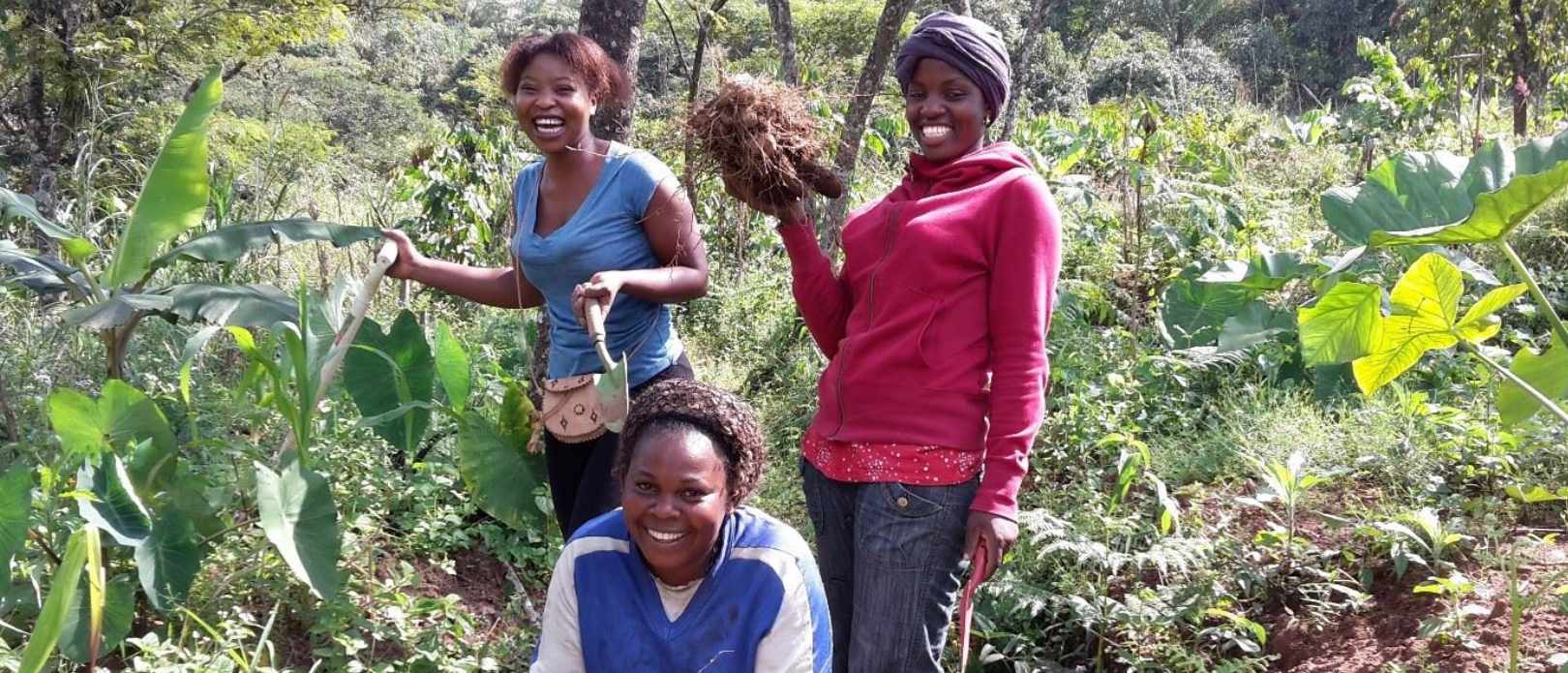 Three women smiling, working with permaculture